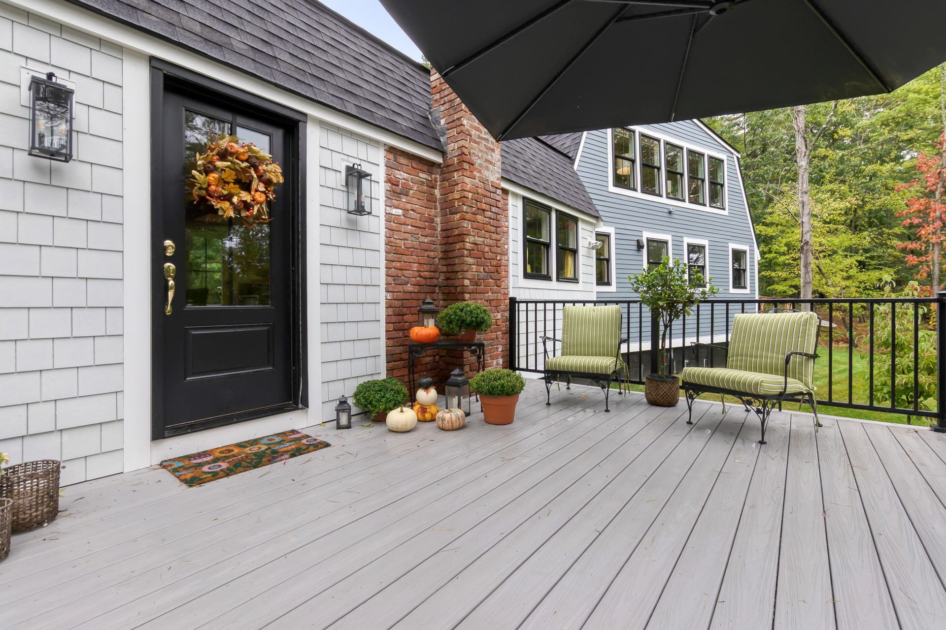 The black front door and the deck with chairs