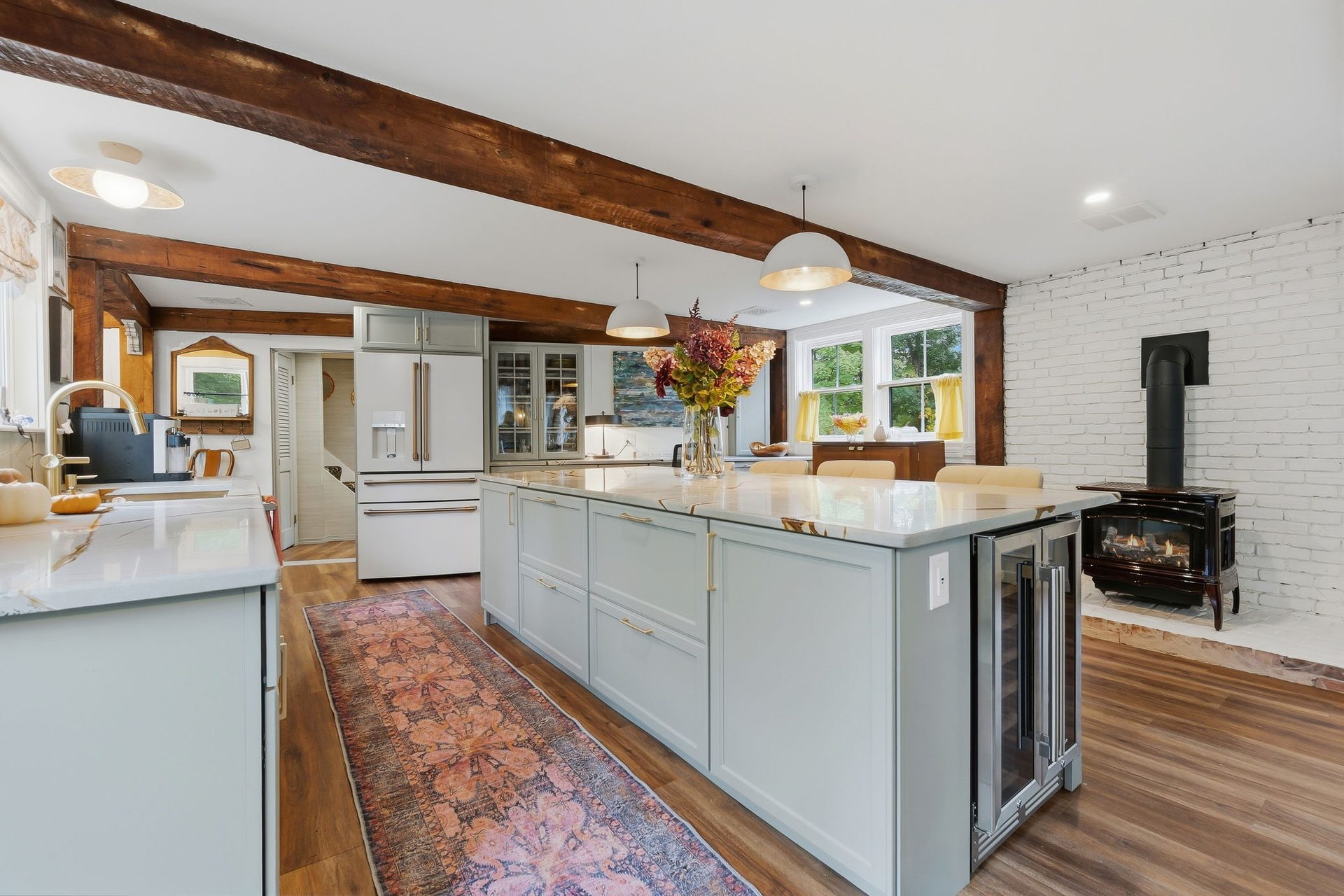 The kitchen island with the stove and brick wall beyond